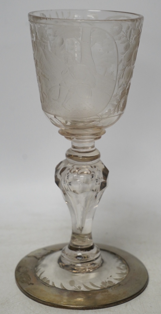 A Victorian engraved tall stemmed wine glass with white metal mounted foot rim, 22cm high. Condition - fair to good